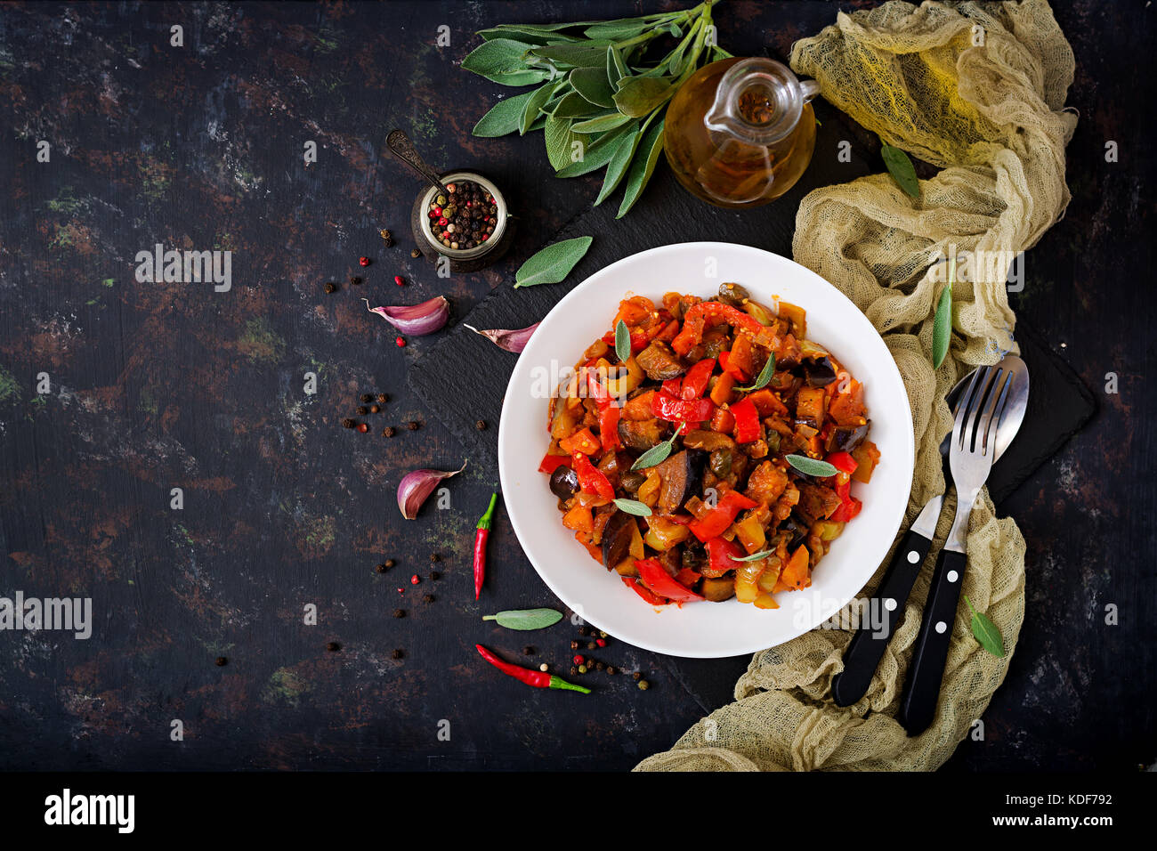 Hot spicy stew eggplant, sweet pepper, tomato and capers. Flat lay. Top view Stock Photo