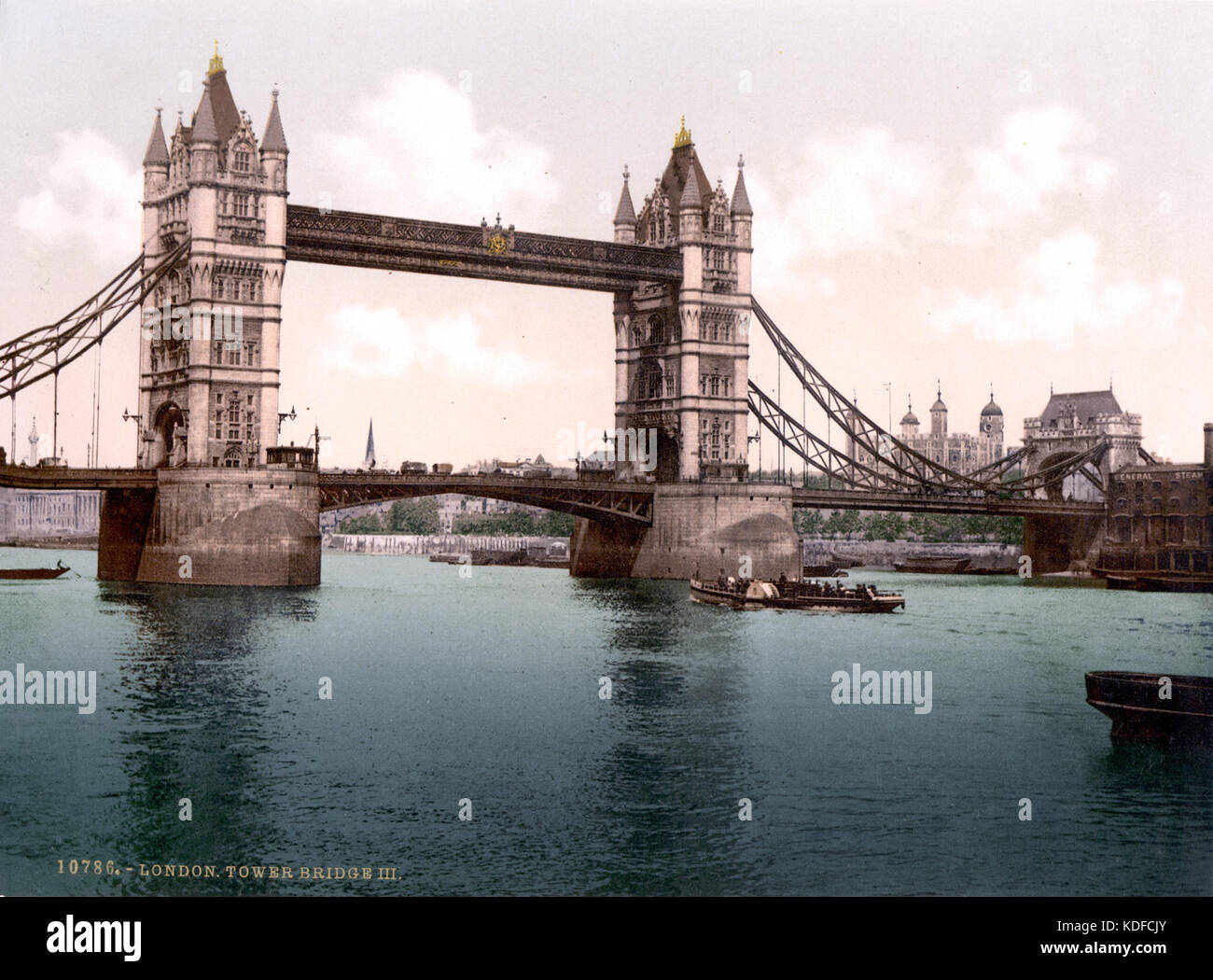 An early 20th-century photograph of the London Tower Bridge in its open position. This historic image captures the bridge's architecture and function in a moment of urban activity during 1900. Stock Photo
