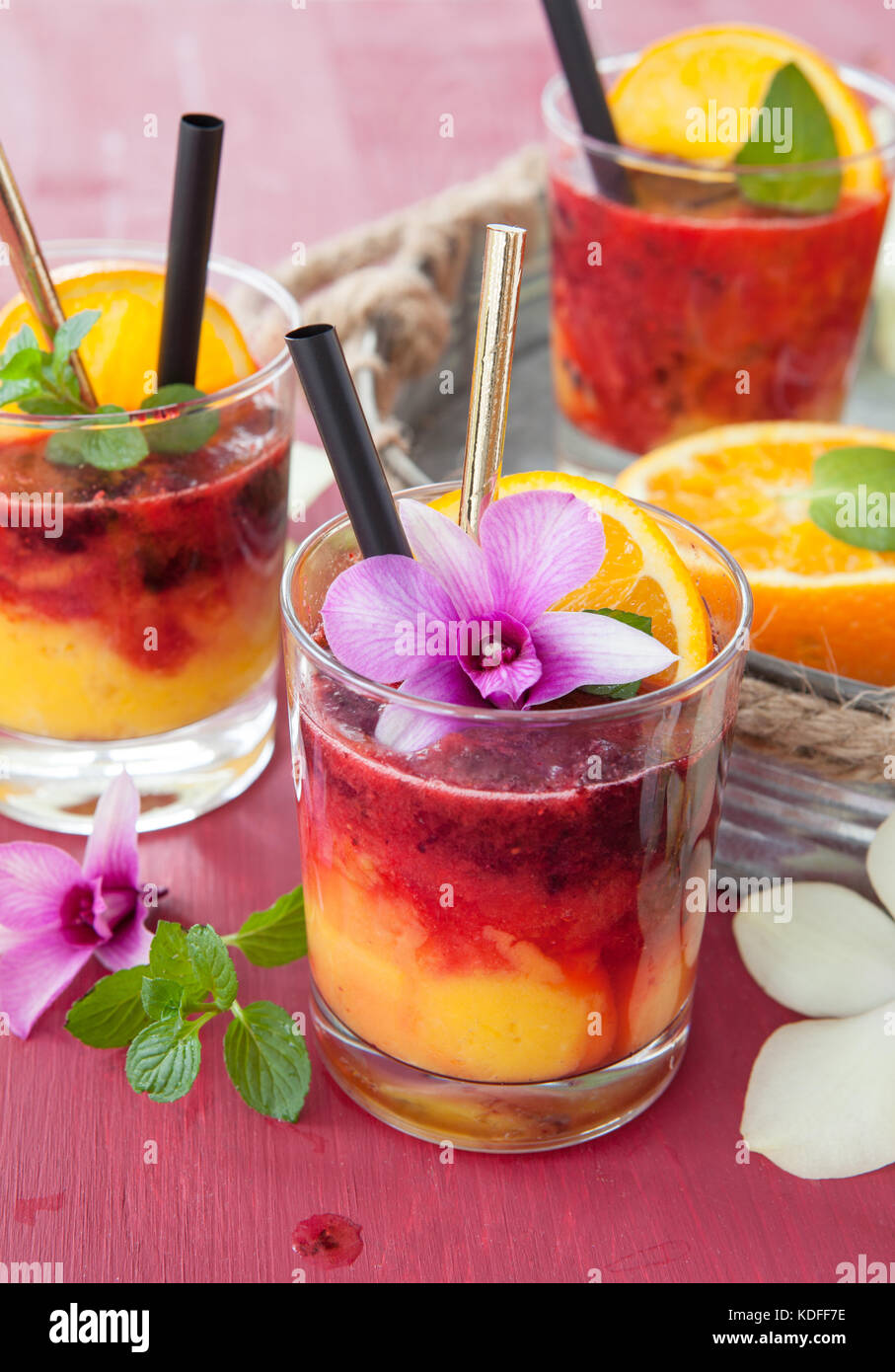 Colorful cocktail with fresh fruits and colorful orchids Stock Photo