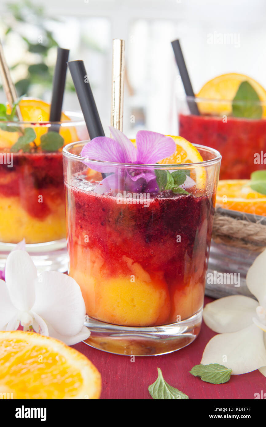 Colorful cocktail with fresh fruits and colorful orchids Stock Photo