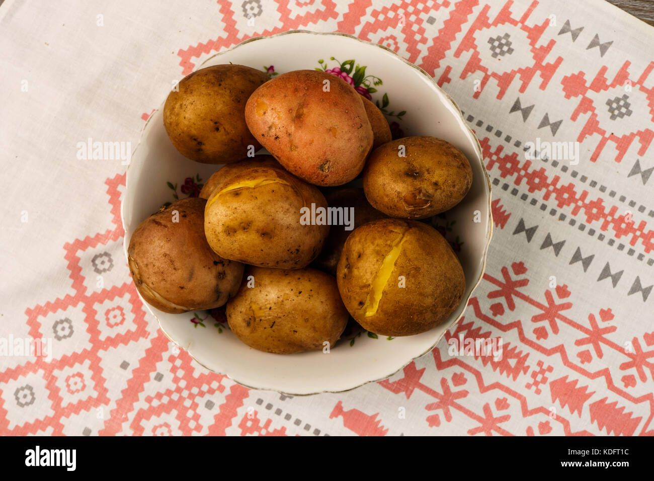 Ukrainian national dish is baked potatoes. Baked whole-potatoes in skins with sauerkraut, pickled red tomatoes and cucumbers Stock Photo