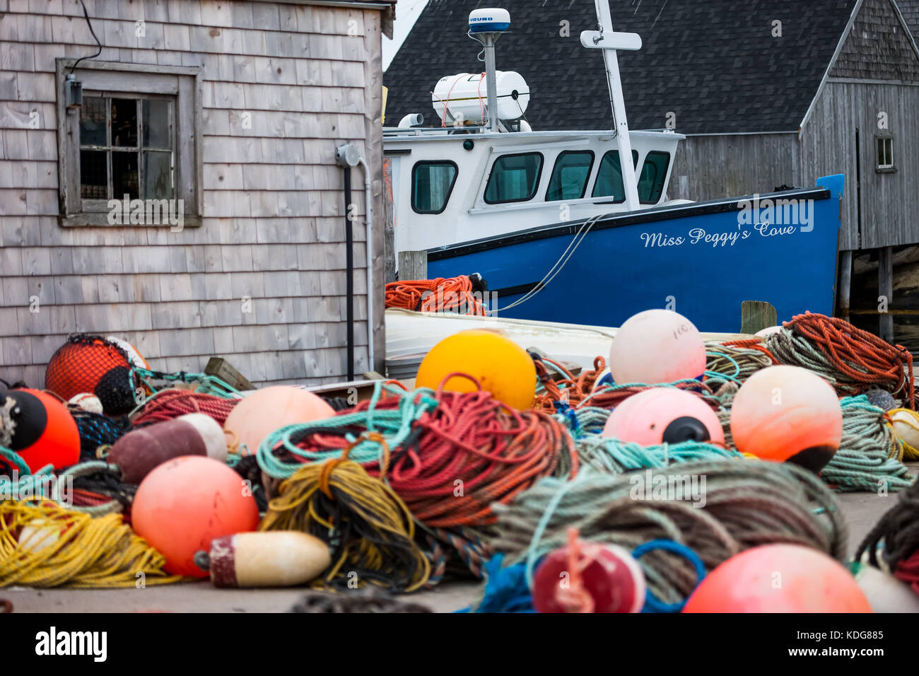 Commercial fishing boats along with their traps, lines and markers tied up to the docks in Peggy's Cove, Nova Scotia on August 30, 2017. Stock Photo