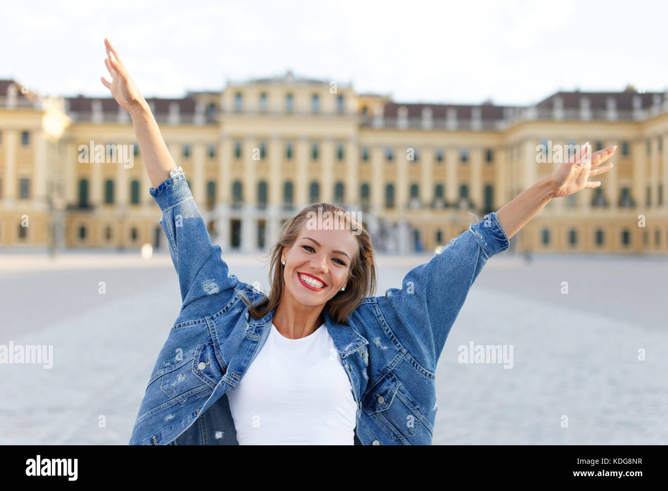 Happy young brunette woman hands up in Vienna, Austria Stock Photo