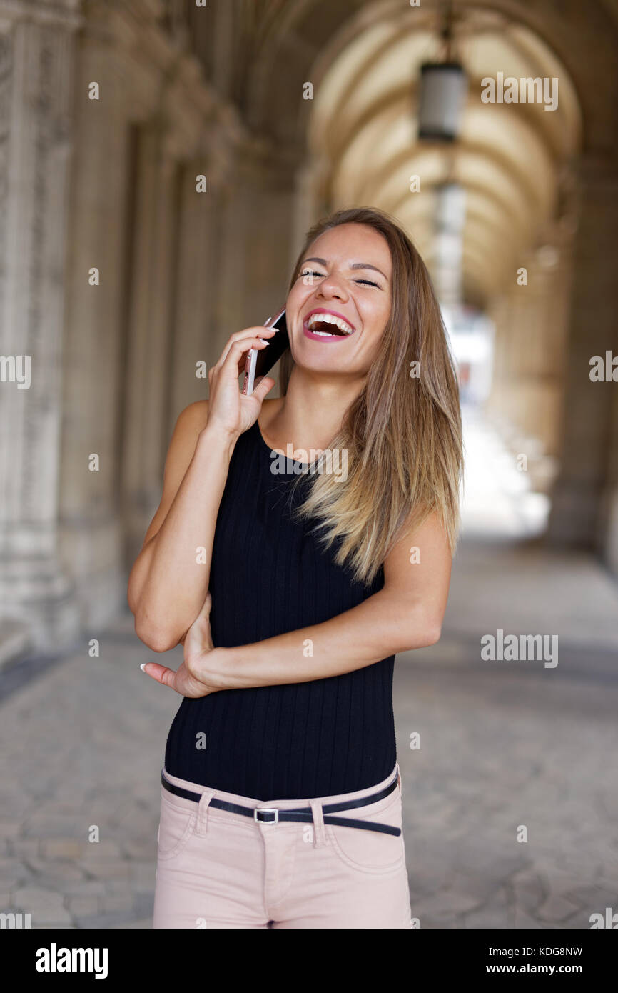 Happy brunette woman calling by phone and laughing outdoor Stock Photo