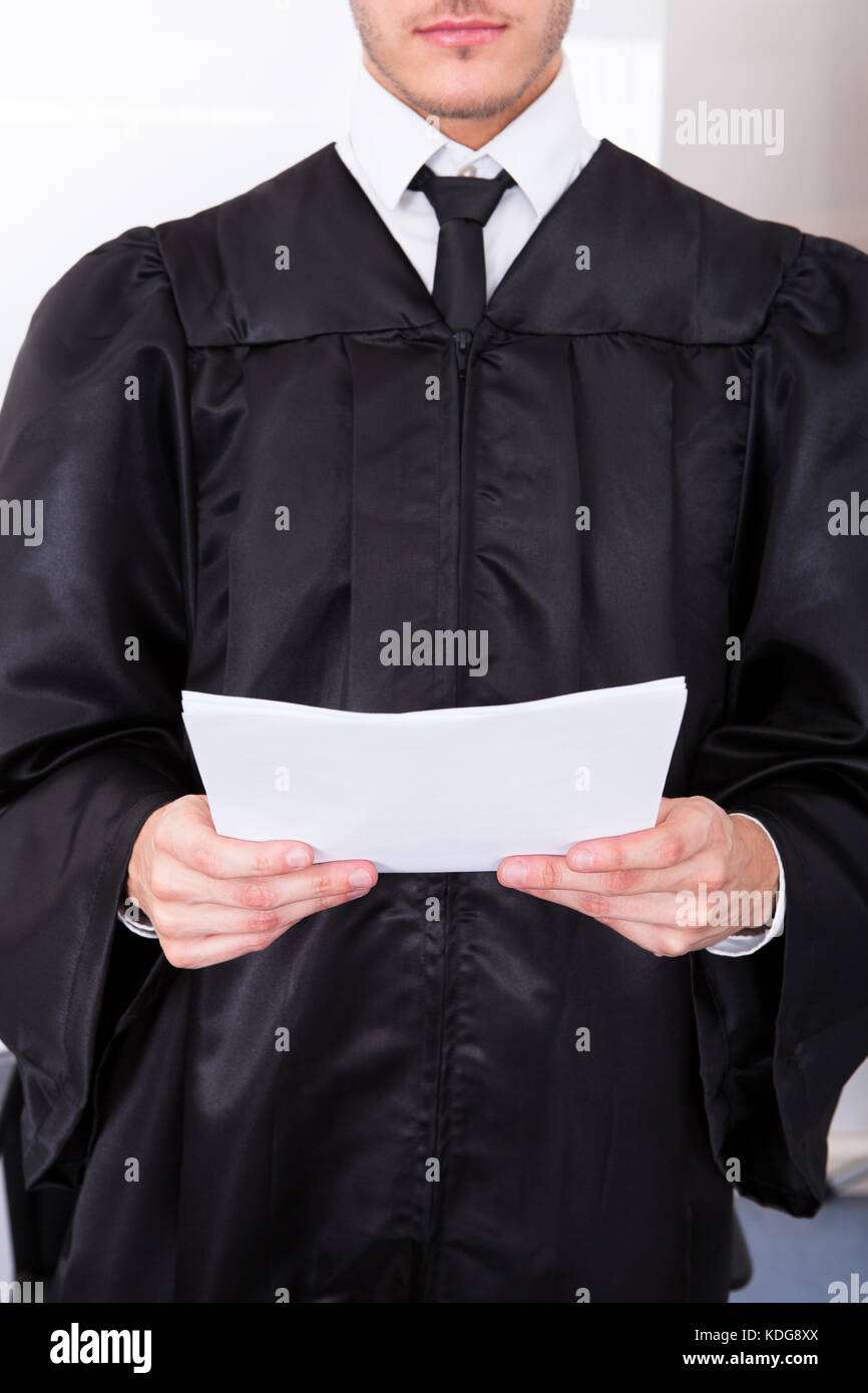Close-up Of Male Judge In Robe Holding Judicial Documents Stock Photo