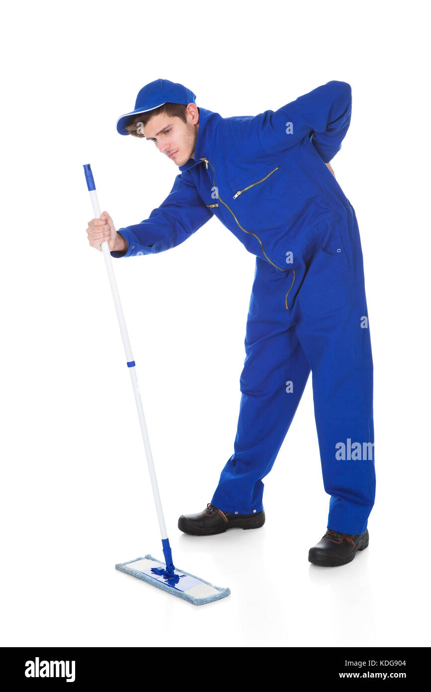 Portrait Of Young Male Worker Suffering From Back Pain Holding Mop