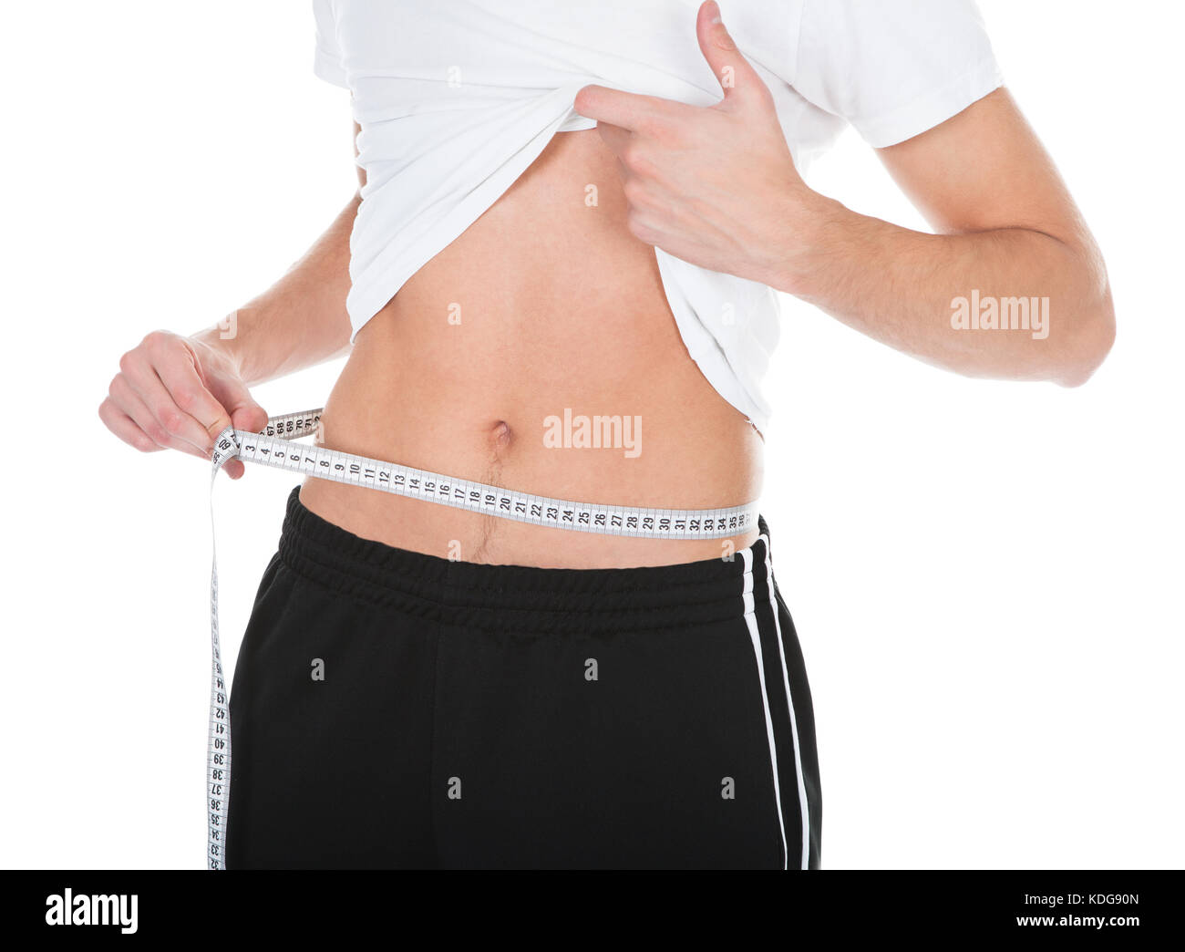 Close-up Of A Happy Young Man Measuring His Waistline Stock Photo