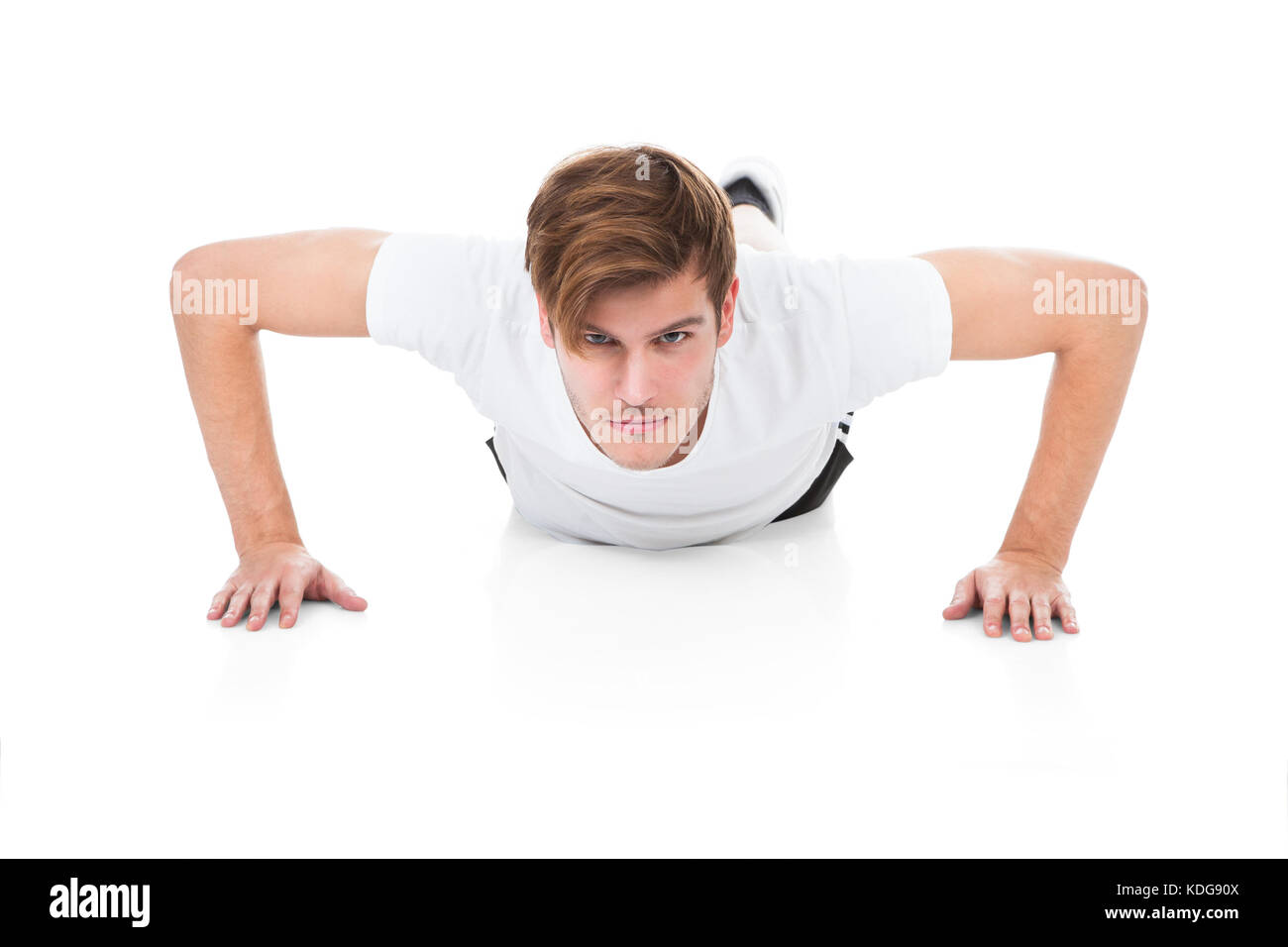 Serious Young Man Doing Pushups On White Background Stock Photo