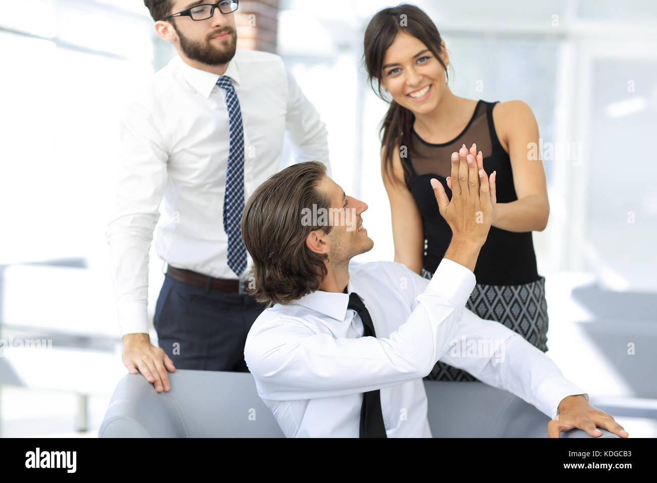 Young business colleagues giving each other a high five Stock Photo - Alamy