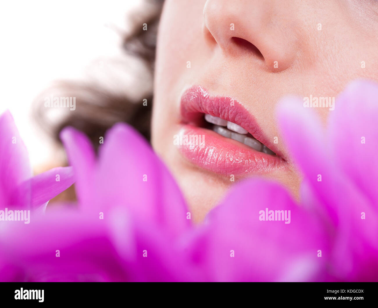 Close-up Of Young Woman In Front Of Purple Flowers Stock Photo
