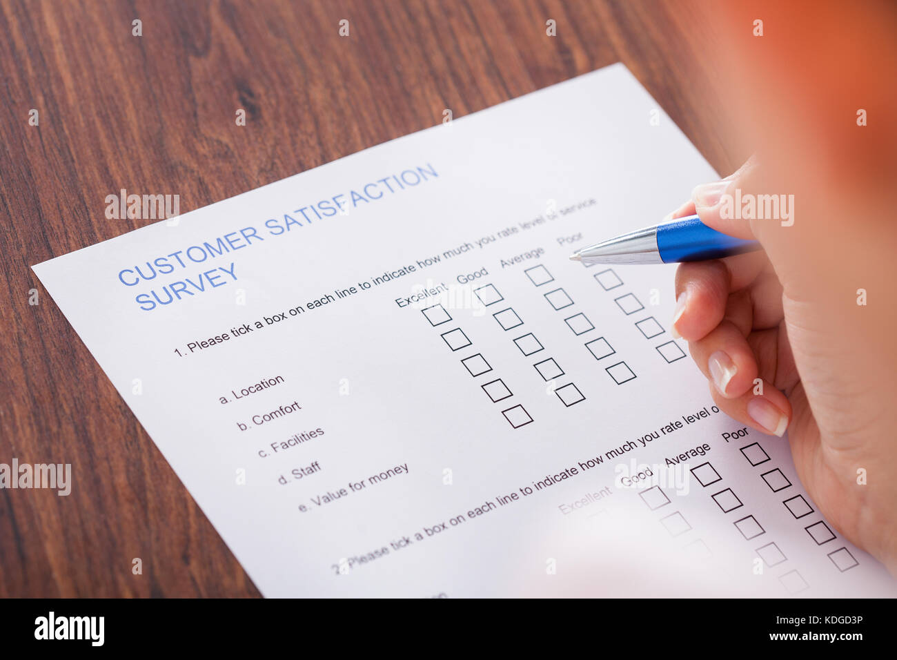 Close-up Of Hand Holding Pen Over Survey Form Stock Photo