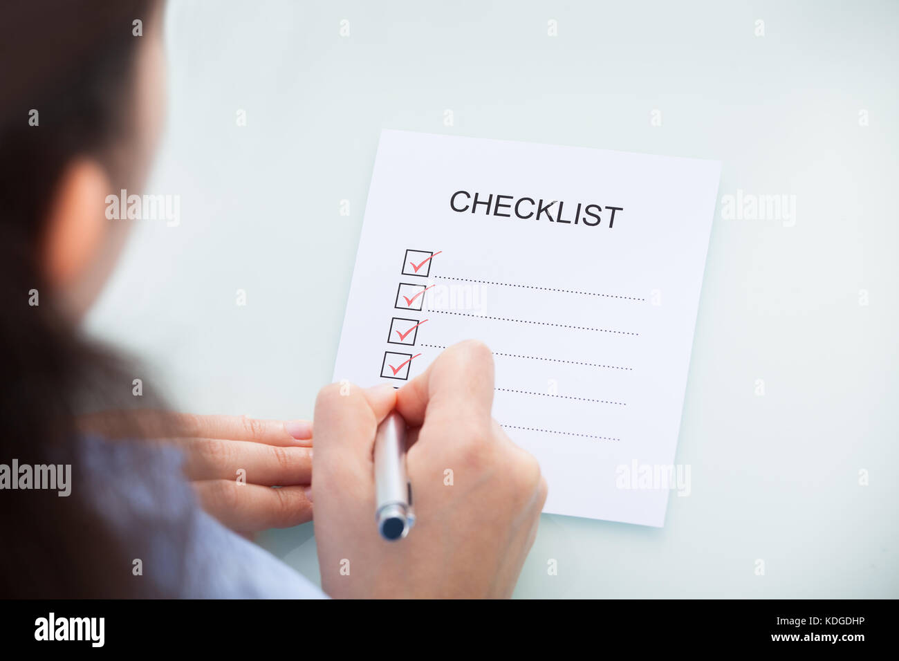 High Angle View Of A Businesswoman Marking On Checklist At Desk Stock Photo