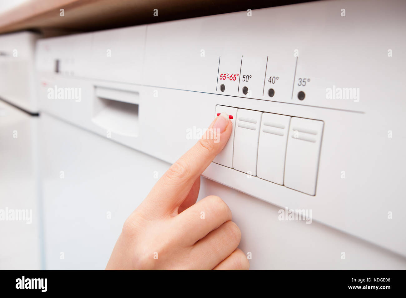 Close-up Of Woman's Finger Pressing Button Of Dishwasher Stock Photo