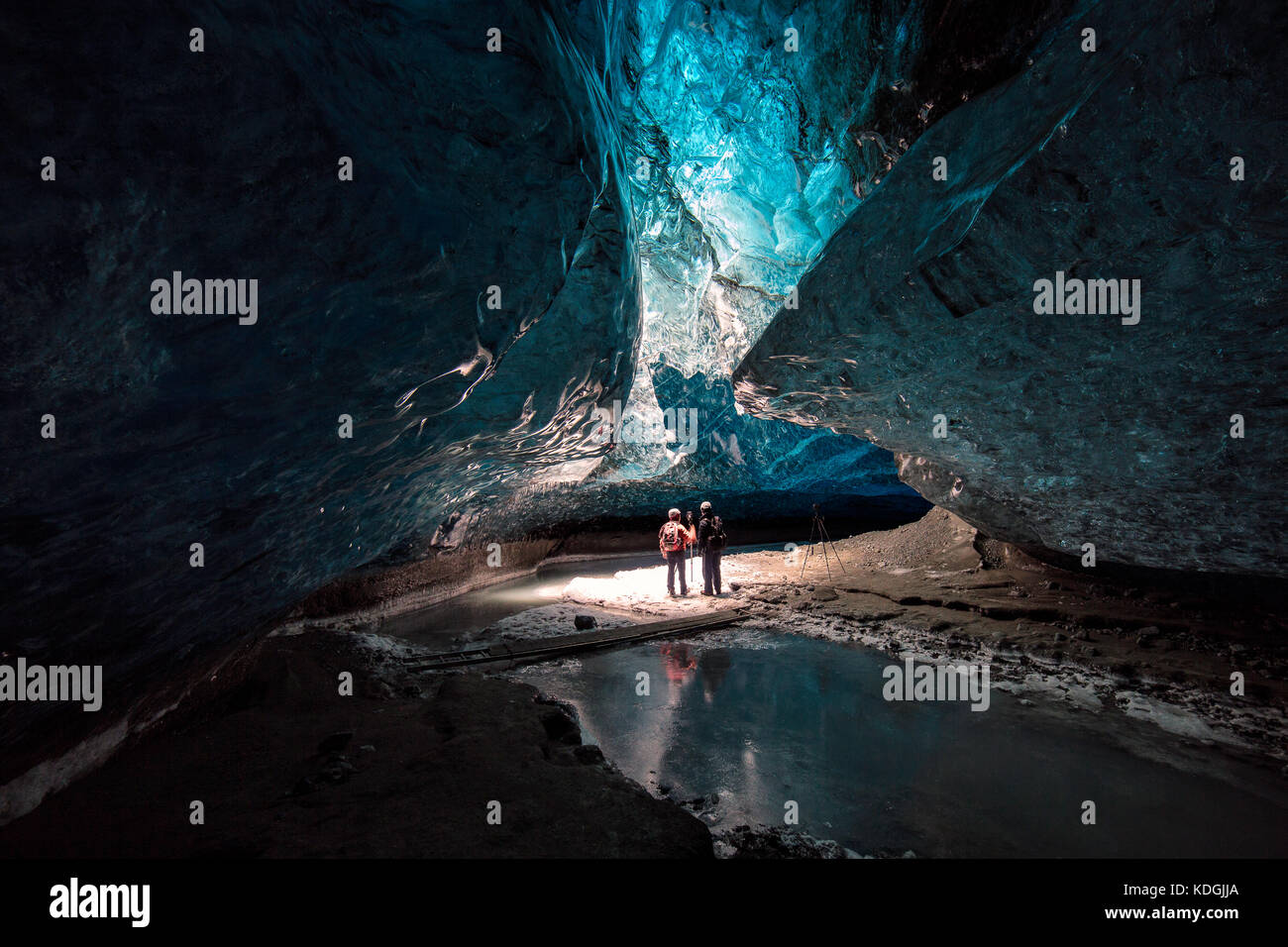 Tour guide with tourist inside a ice cave, showing fantastic colors and texture as well as the scale Stock Photo