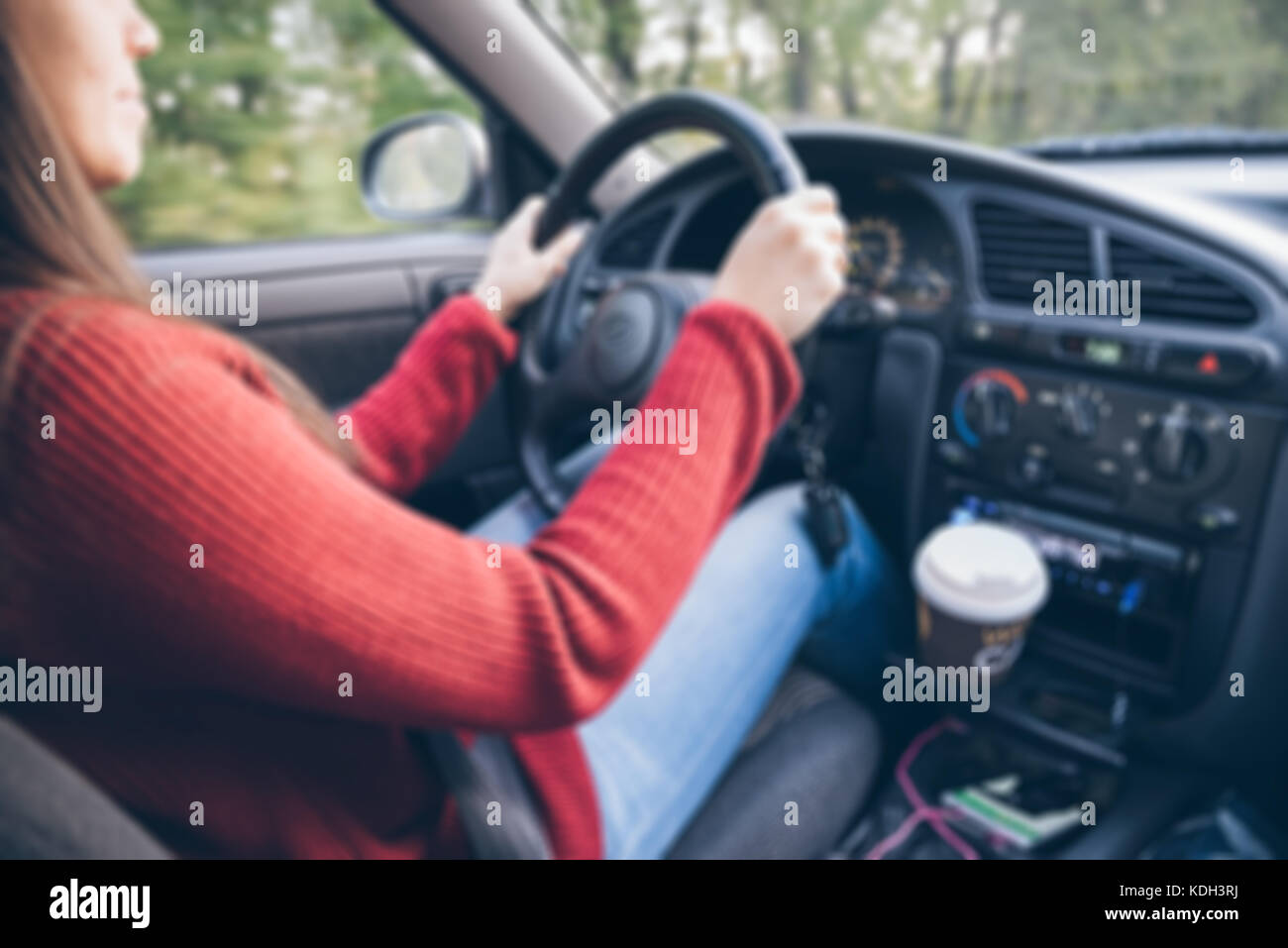 Happy young woman driving her car with coffee Stock Photo - Alamy