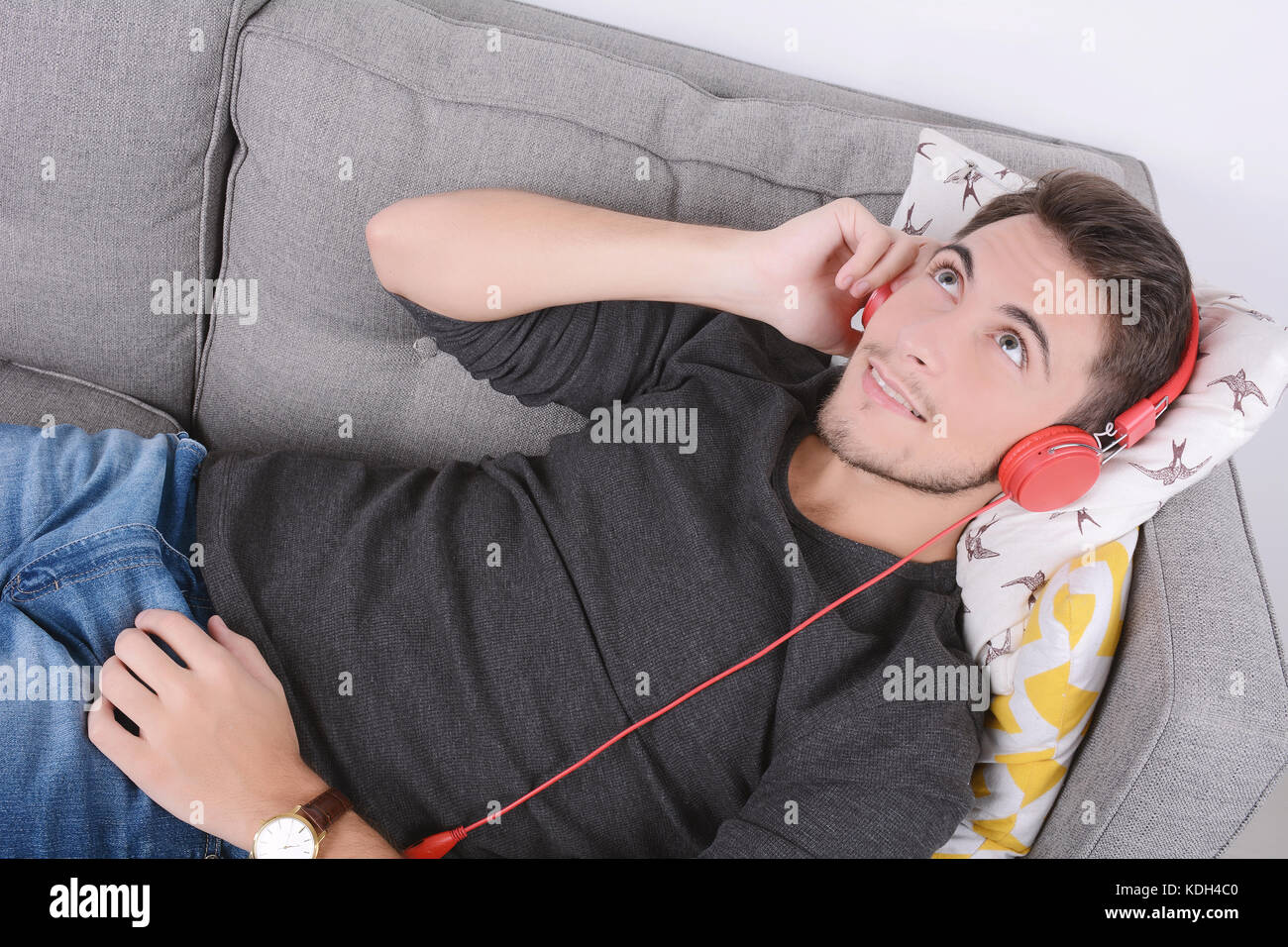 Attractive young man listening to music with headphones and relaxed on ...