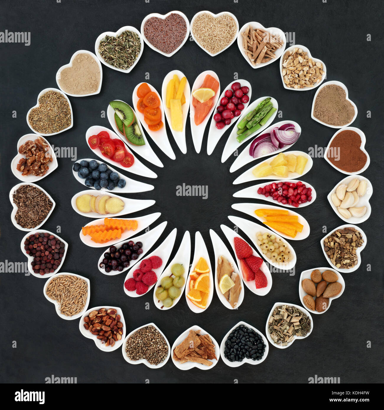 Health food wheel for a healthy heart concept with vegetables, fruit, fish, nuts, seeds, supplement powders, cereal and herbs for herbal medicine. Stock Photo