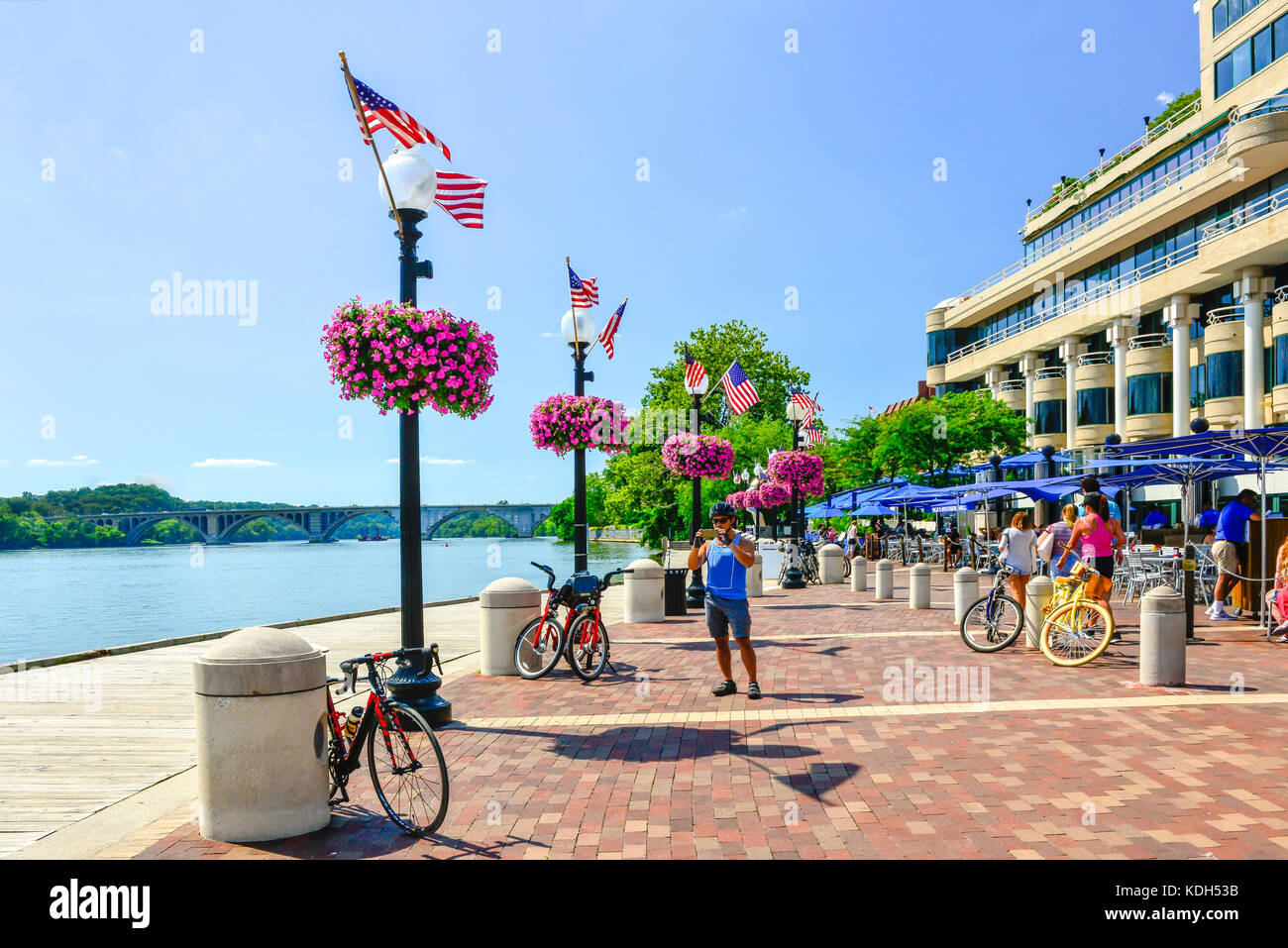 Bicyclists enjoy The Washington Harbor mixed use development on the banks of the Potomoc  river in Georgetown district of Washington, DC, USA Stock Photo
