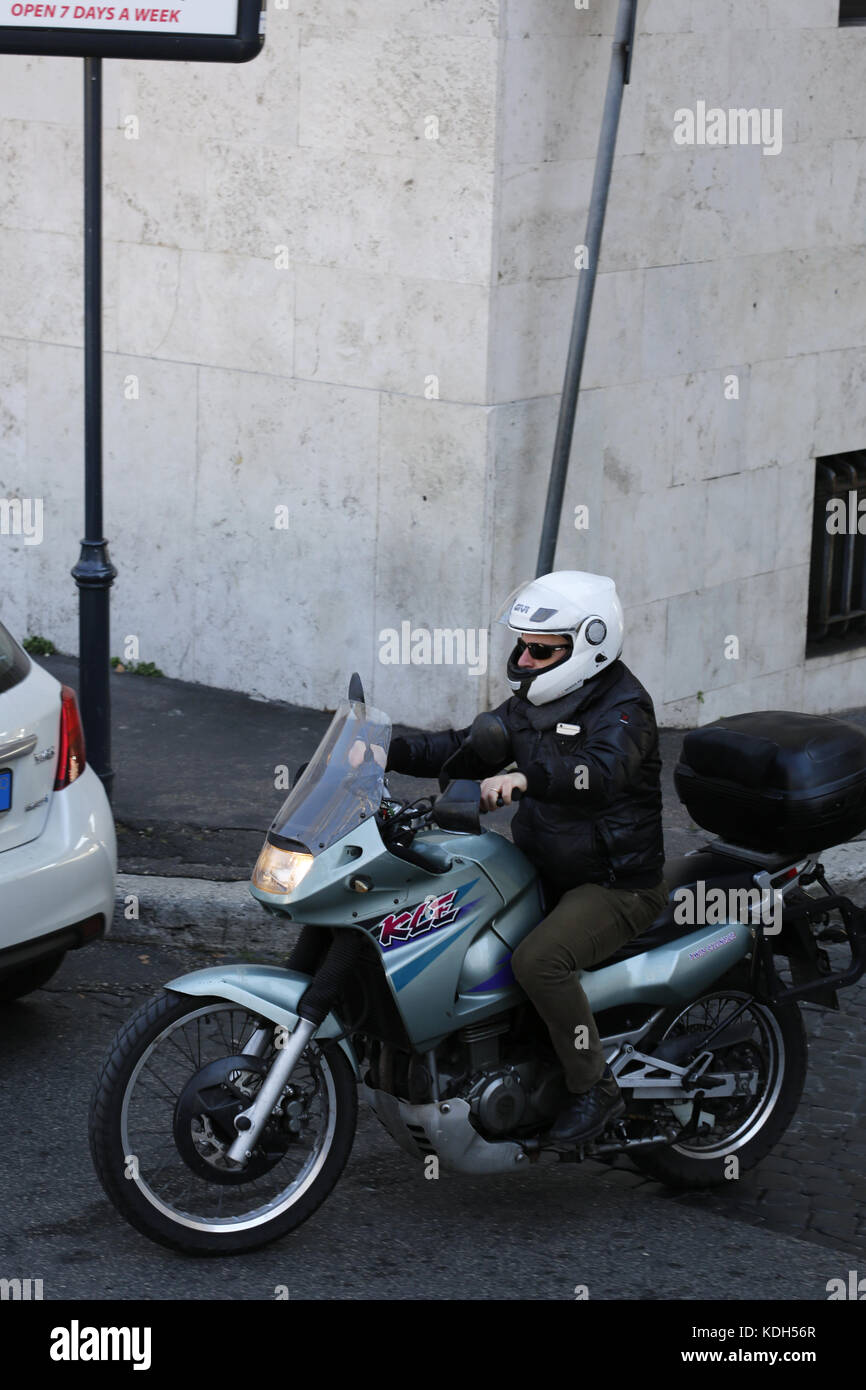 Male on a motor bike on the streets of Rome viewed slight;y from above. Stock Photo