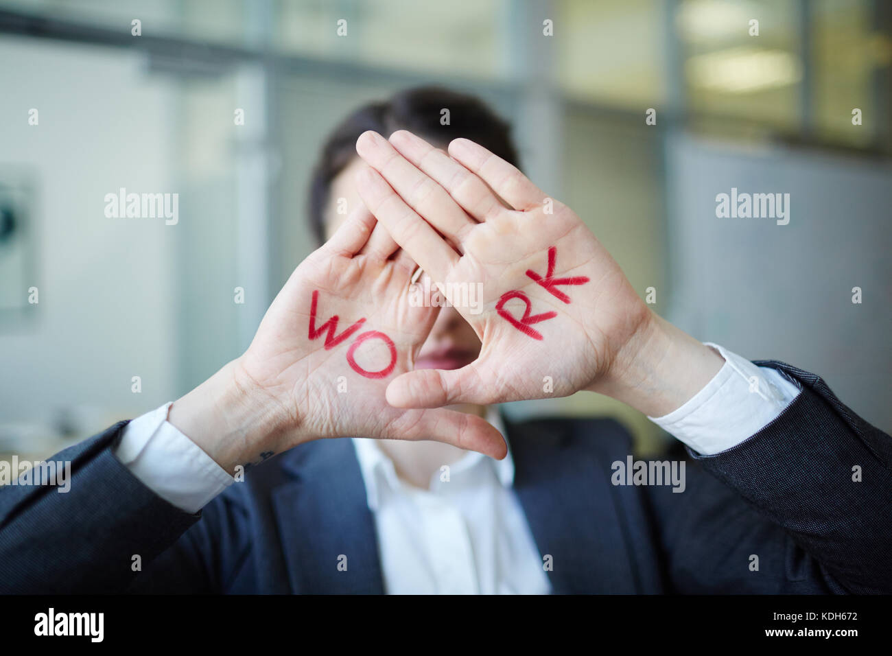 Businesswoman showing her palms with word work written by red lipstick Stock Photo
