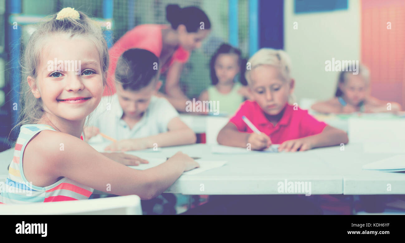 Portrait of cheerful pupil girl studying in school class Stock Photo ...