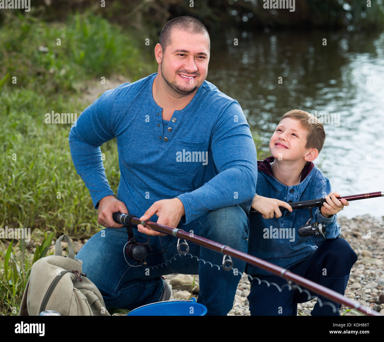 https://c8.alamy.com/comp/KDH86T/laughing-father-and-boy-fishing-with-rods-in-summer-day-KDH86T.jpg