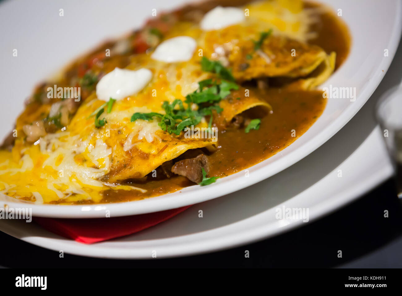 Traditional enchilada corn tortilla with chili pepper sauce in