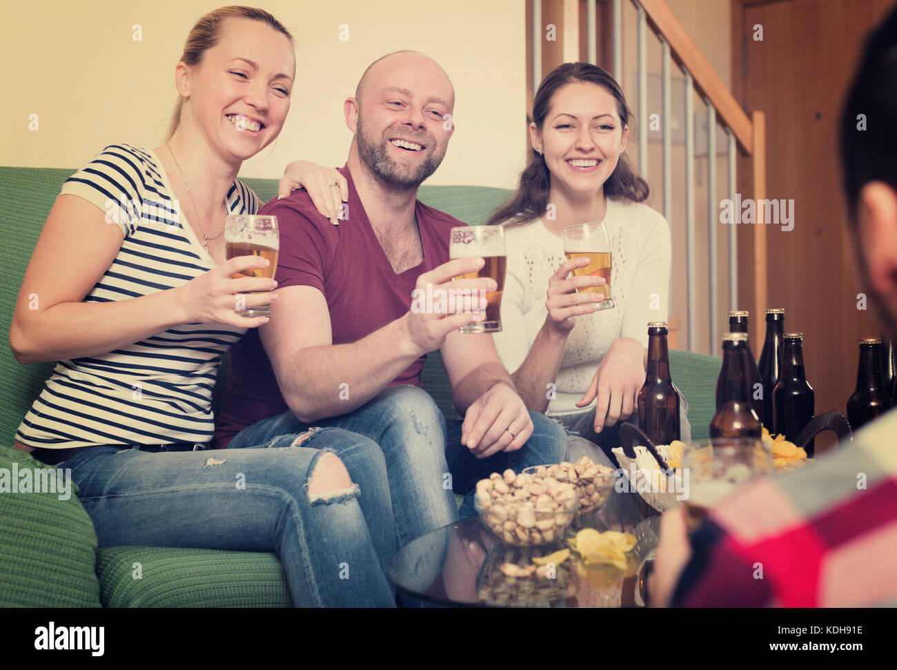 Happy friends hanging out with beer and snacks in home Stock Photo - Alamy