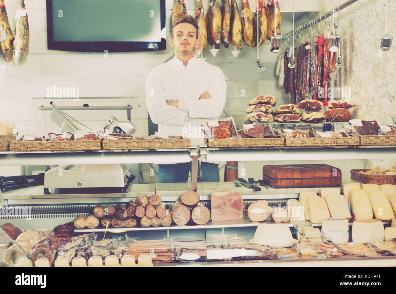 Grumpy Shop Assistent Smiling cheerful shop assistant in grocery shop greeting customers ...