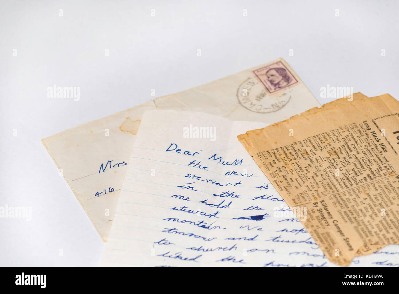 An old hand written letter, envelope and newspaper article to a Mum Stock Photo