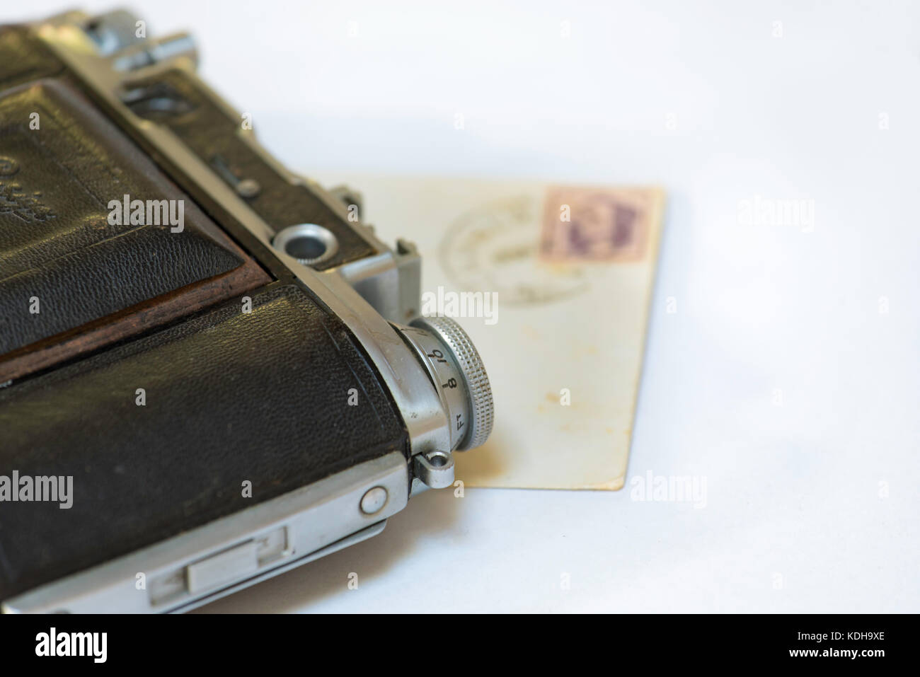 An old film camera and an envelope lying flat Stock Photo