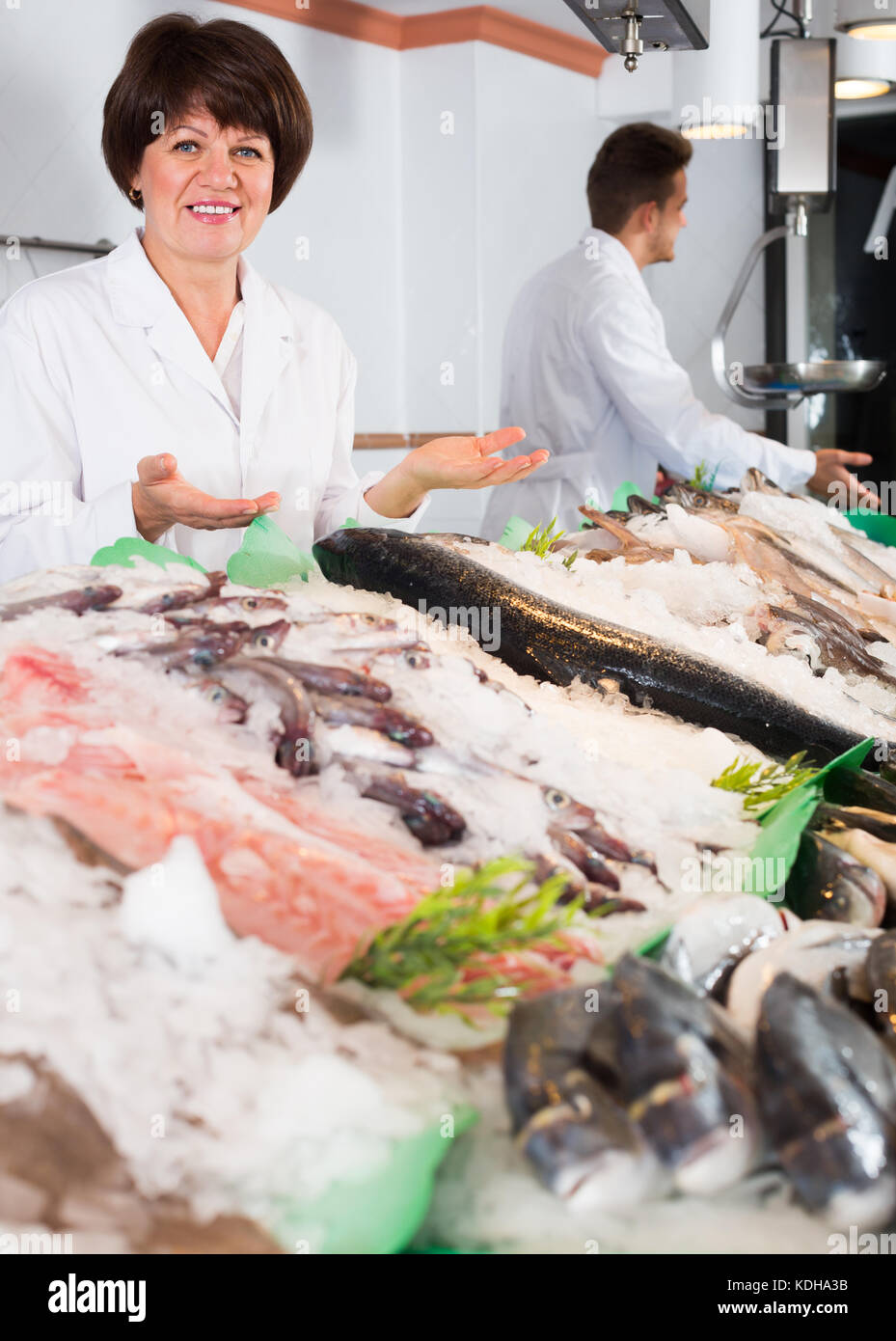 Ordinary fish and seafood store with two laughing sellers indoors Stock