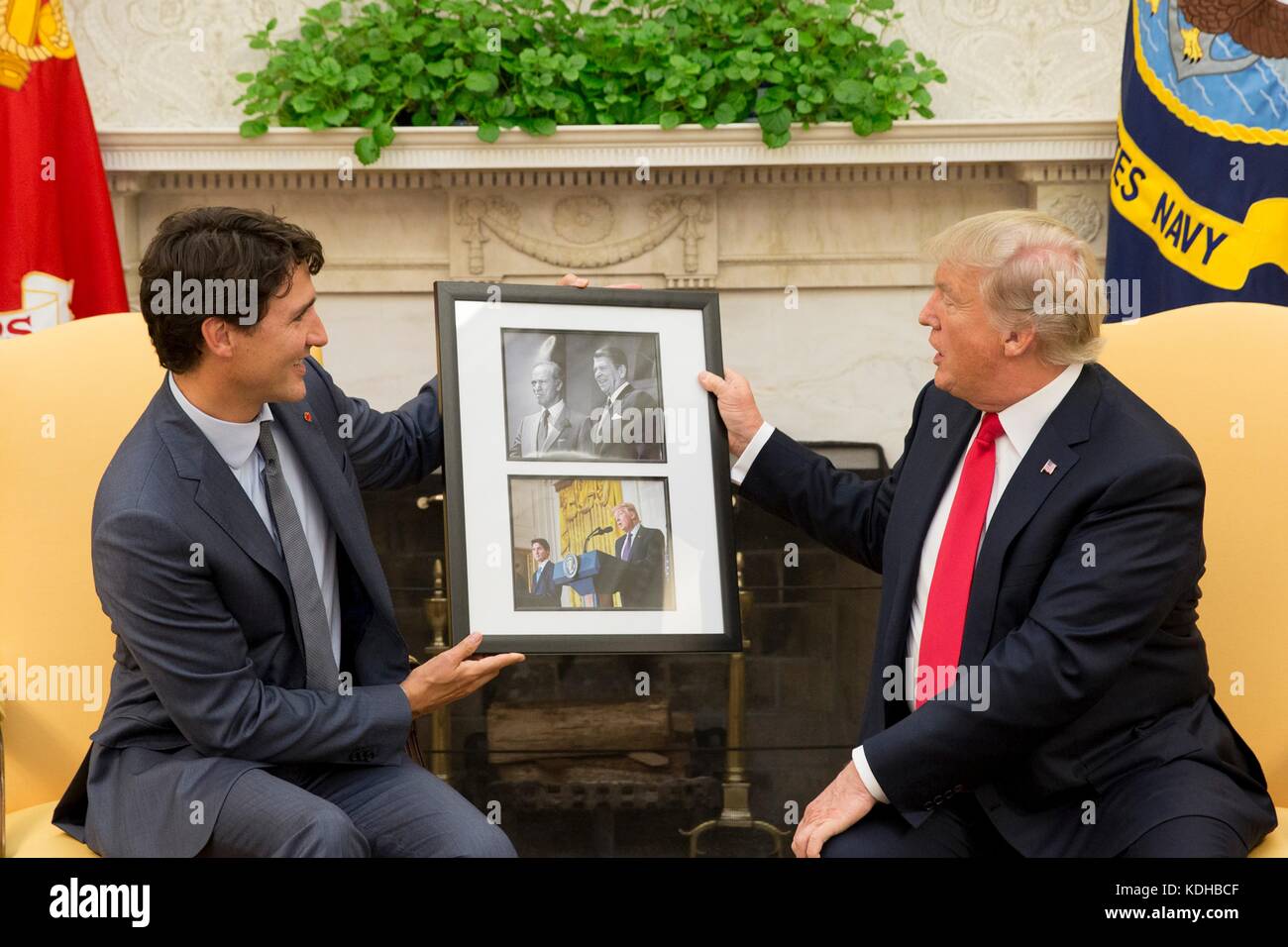 U.S. President Donald Trump is gifted a framed photo by Canadian Prime Minister Justin Trudeau during their Oval Office meeting at the White House October 11, 2017 in Washington, D.C. The photos show Trudeau’s father Prime Minister Pierre Trudeau meeting President Ronald Reagan in 1983, and a photo of President Trump and Prime Minister Trudeau meeting earlier this year. Stock Photo