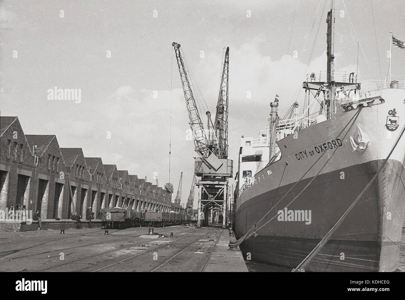 1960s, historical, the container ship, City of Oxford, moored at London Docks, London, England, UK. In the picture are the rail freight wagons beside storage depots. Built in 1948 in Glasgow on the Clyde by John Brown & Co for Ellerman Lines, the cargo ship was steam-powered and survived until 1978 when it was broken up. Stock Photo