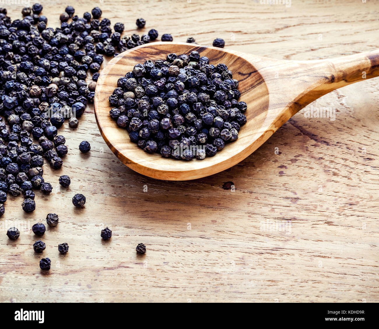Table Peper Closeup black pepper in wooden spoon on shabby teak wood table ...