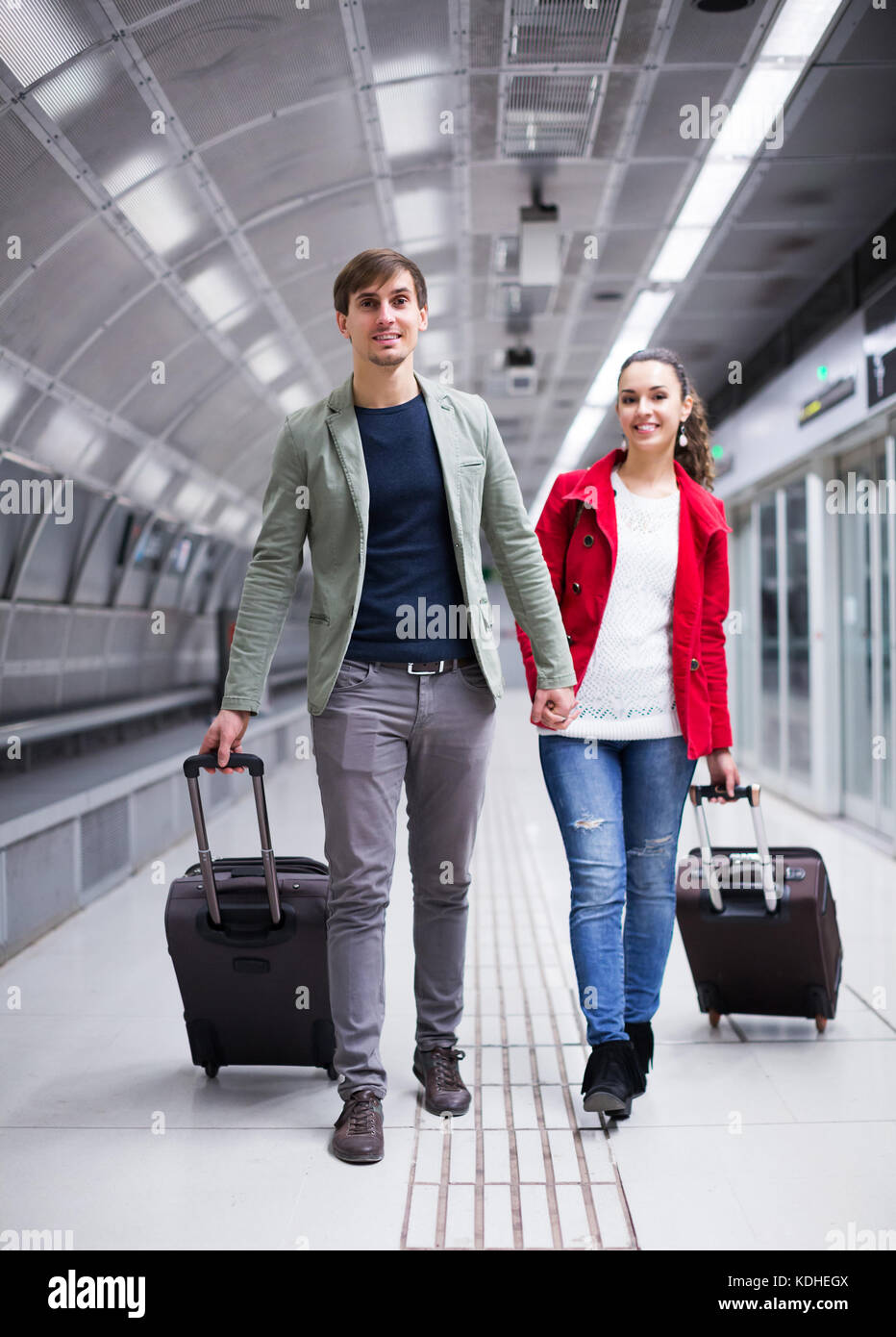 Positive people carrying luggage at metro terminal Stock Photo Alamy