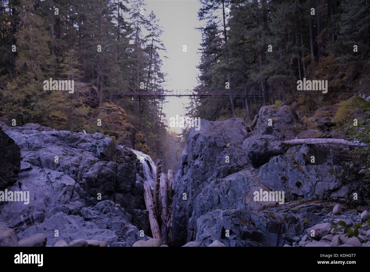 Beautiful view of man made bridge above waterfall from behind the waterfall. exploring British Columbia/ Canada Stock Photo