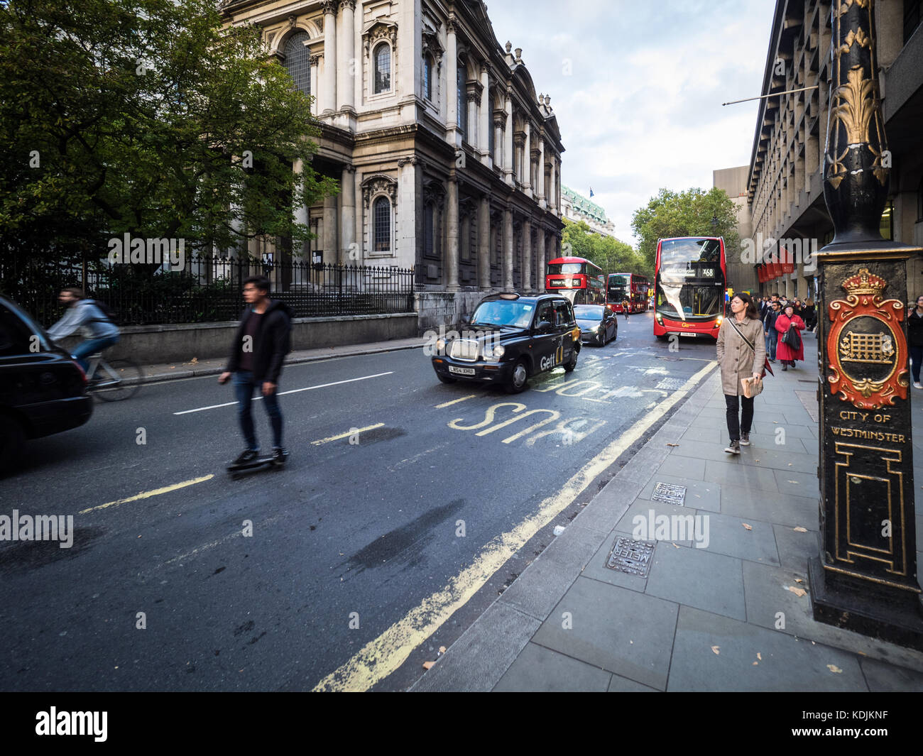 Skateboarding Commuter London - a man skateboards through traffic on the Strand in central London UK Stock Photo