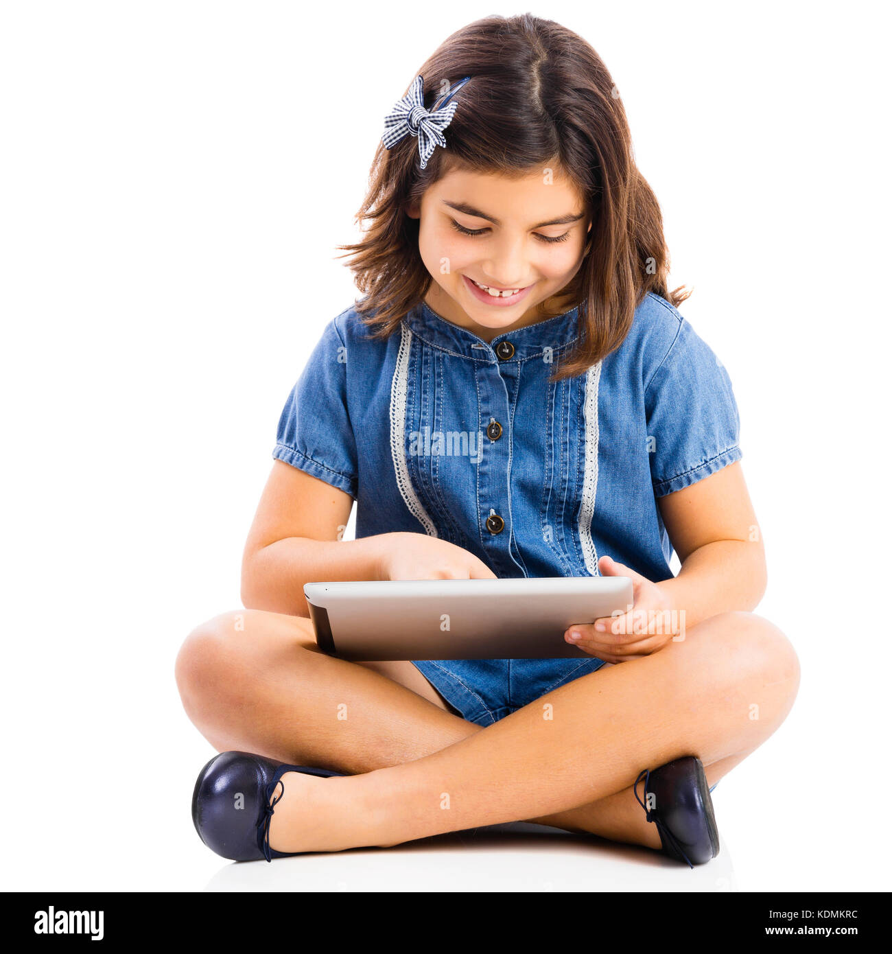 Young girl sitting on floor and using a tablet Stock Photo - Alamy