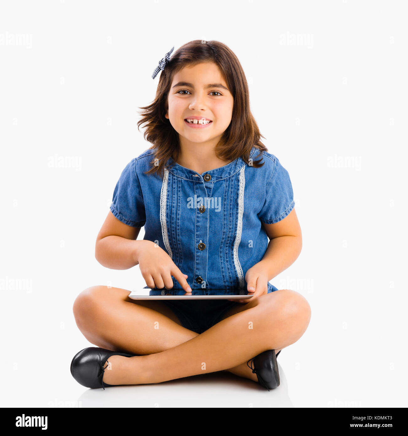 Young girl sitting on floor and using a tablet Stock Photo - Alamy