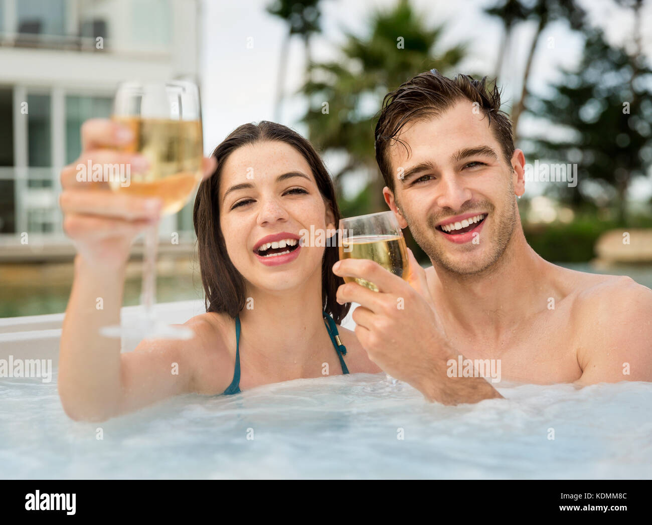 Young couple inside a jacuzzi and toasting Stock Photo