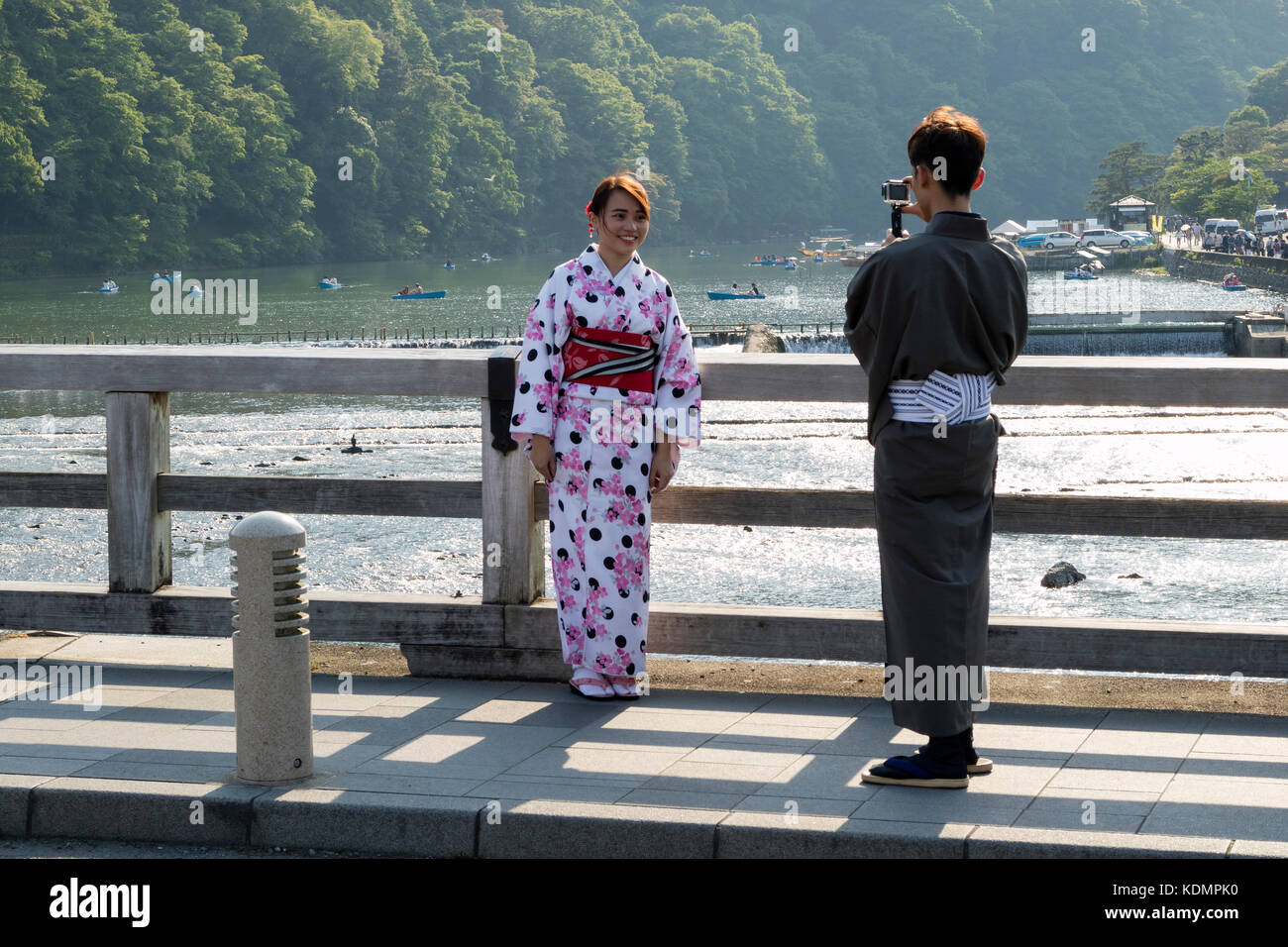 Kyoto, Japan - May 20, 2017:  Woman in kimono is phtographed on the historical Togetsukyo Bridge over the Katsura River at Otsuki, Yamanashi, Japan Stock Photo