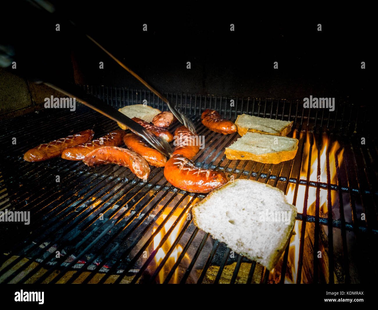 Fried sausage and bread on grill with fire Stock Photo