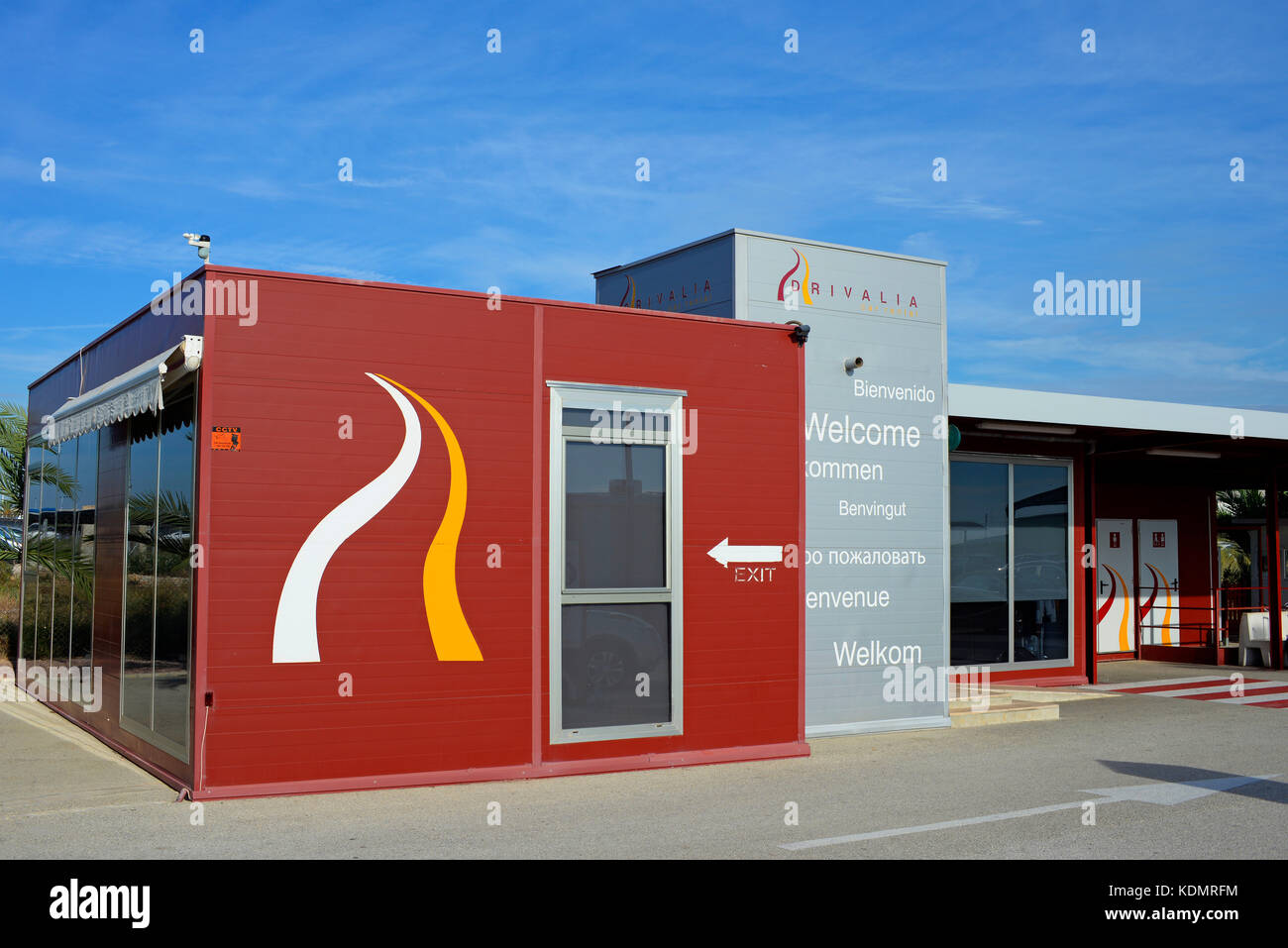 Drivalia car hire office at Alicante Airport Spain. Vehicle hire. Welcome in various languages. Customer toilets. Waiting area. Blue sky Stock Photo