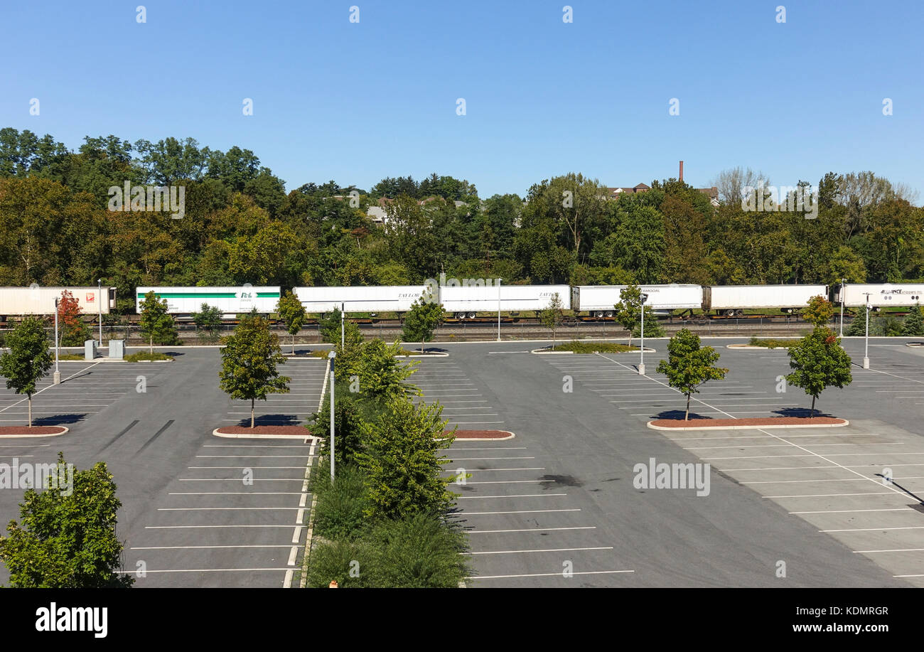 Empty parking lot with freight train passing by in background, Bethlehem, Pennsylvania, United states. Stock Photo