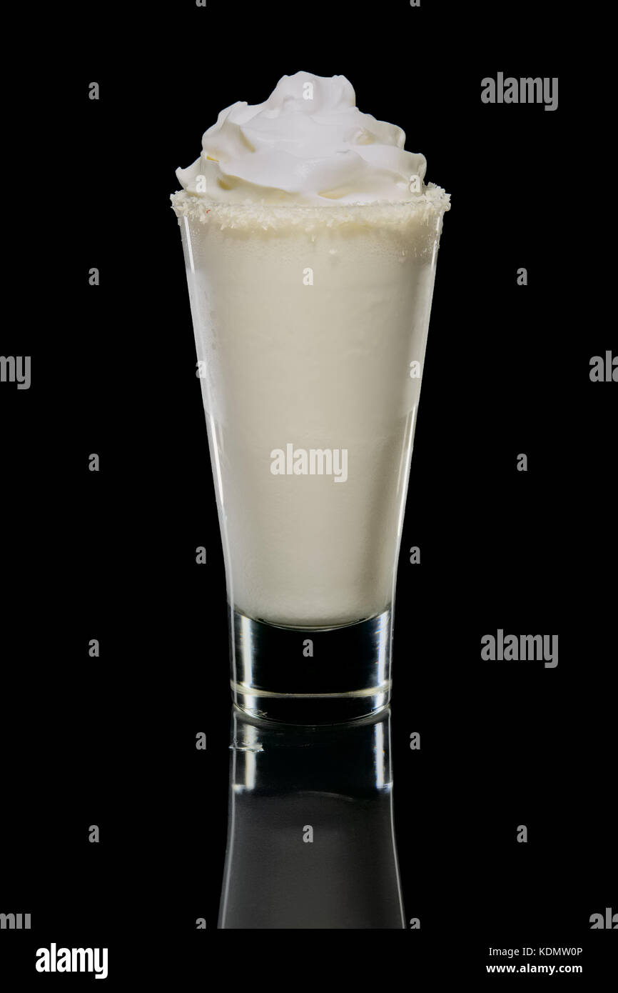 Coconut cream and rum cocktail in highball glass isolated. Pina colada drink. Stock Photo