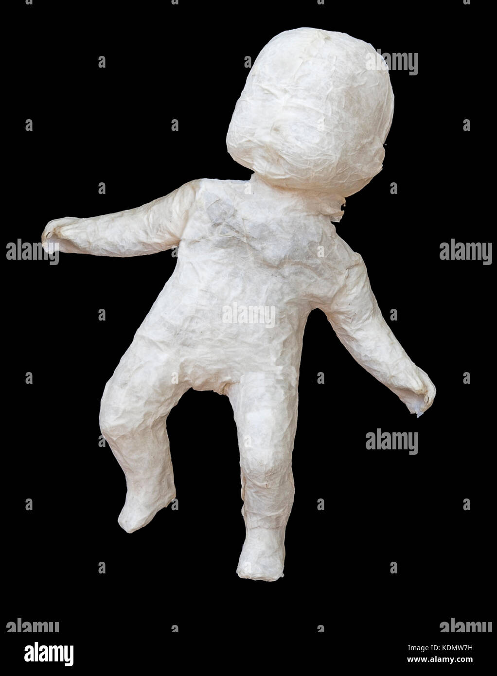 Paper mache infant doll on black background. Stock Photo
