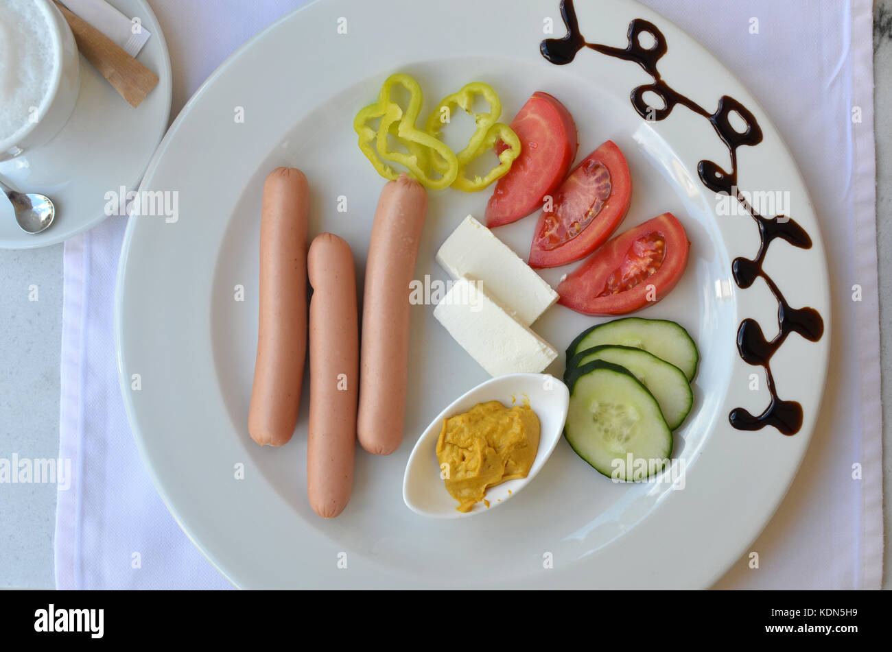 Plate with served breakfast - hot dogs and fresh vegetables Stock Photo