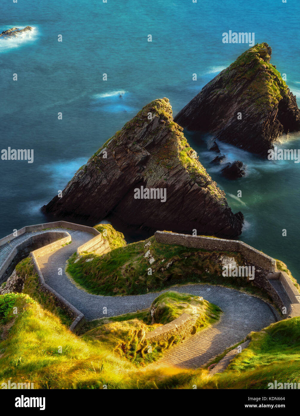 Dunquin Pier with offshore rocks and winding road. County Kerry, Ireland Stock Photo