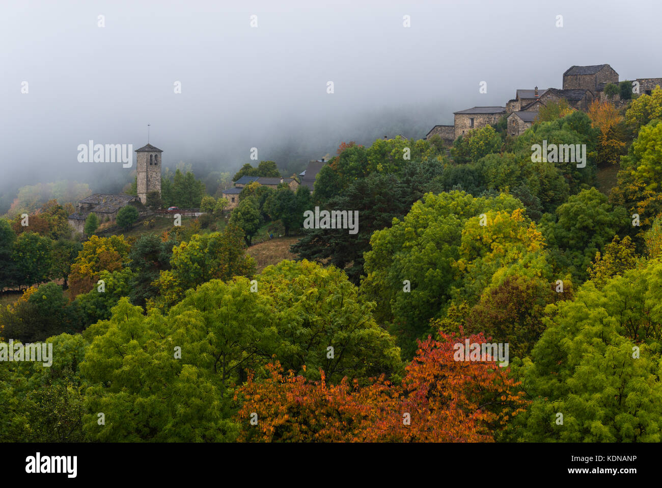 The small village of Fanlo (Huesca) wrapped between fog and vegetation Stock Photo